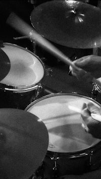 a man playing drums in black and white